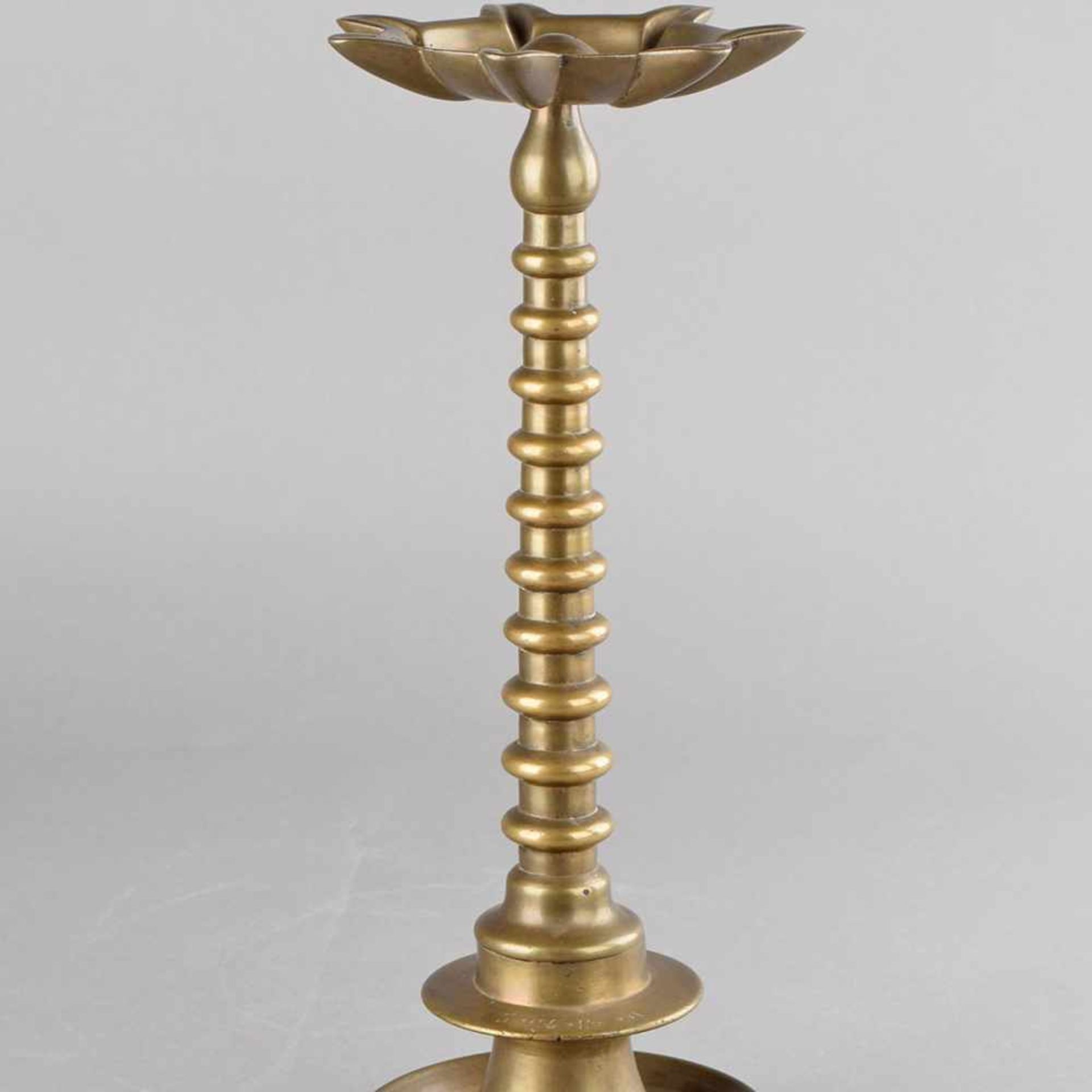 Chanukka-Leuchter Bronze, profilierter Rundfuß, in Manschette hebräische Schrift, schlanker Schaft