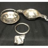 Hallmarked Silver: Baby ring Birmingham and a tea strainer and holder Sheffield. 1.8oz.