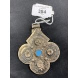 Jewellery: Islamic white metal pendant with a central turquoise coloured boss, 1¼ozs.