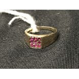 Hallmarked Gold: Dress ring, nine small ruby coloured stones in a square signet style design. Set in