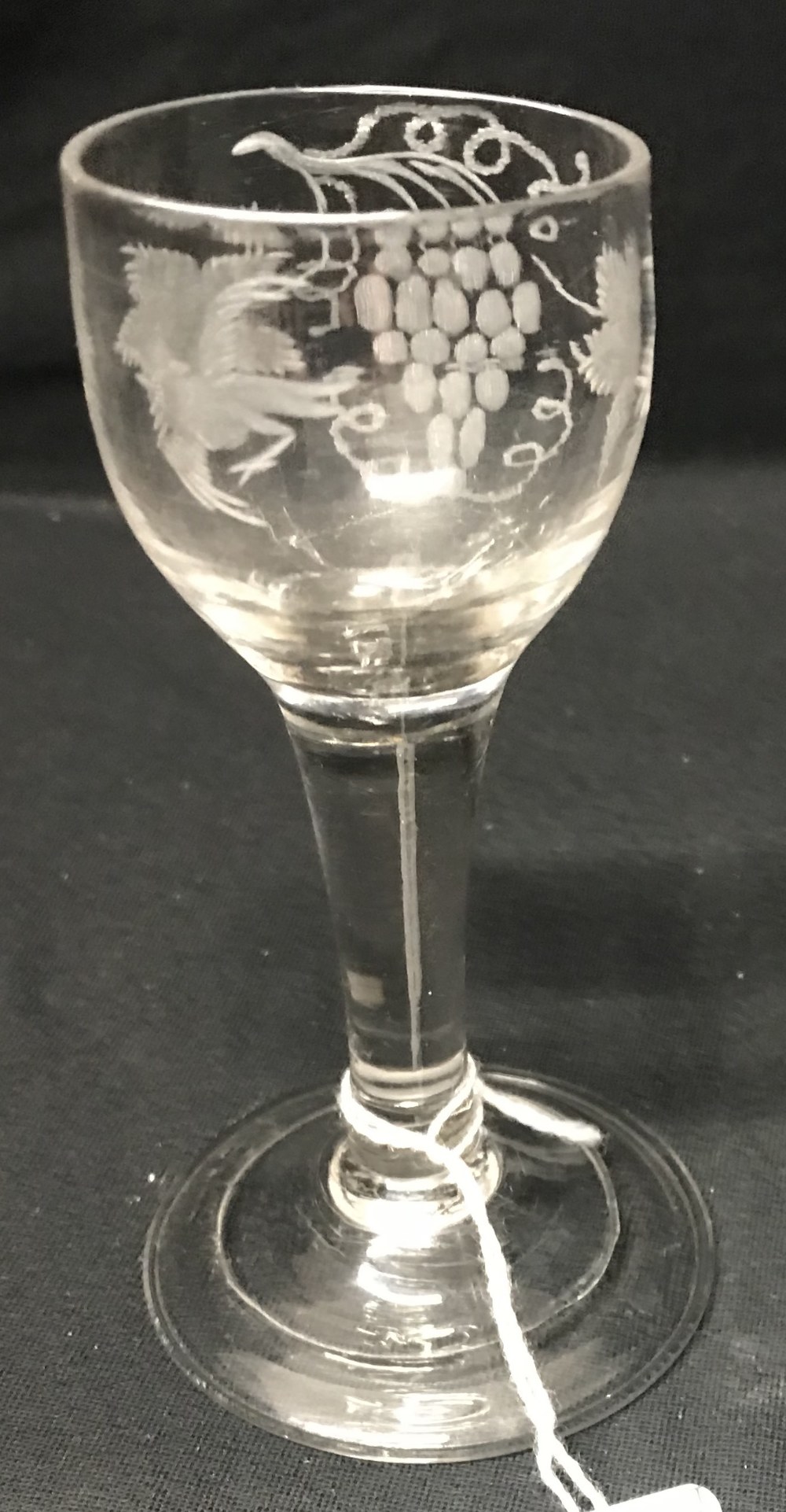 18th cent. Wine glass, ovoid bowl engraved with vine leaves and flying bird, tapering stem, uneven