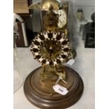 Clocks: 20th cent. Brass skeleton clock chiming on the hour, treen base and circular glass dome.