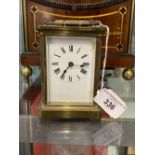 Clocks: 20th cent. Brass and glass carriage clock, enamel white face.