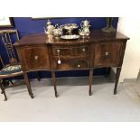 20th cent. Mahogany sideboard, serpentine fronted, two door and two drawers, with brass lions head