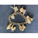 Jewellery: 9ct gold charm bracelet with solid lines and ten 9ct charms. Approx 33gms.