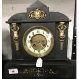 Clocks: 19th cent. Black slate mantel clock with figurines, enamel and brass face and coil chime.