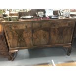 20th cent. Walnut veneered sideboard, three drawers above three cupboards on club feet.