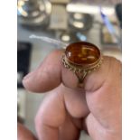 Jewellery: 9ct. Gold ring with oval inset amber setting with inclusions.