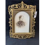 19th cent. Gilt brass openwork frame with a period photograph of a young woman. 9ins.