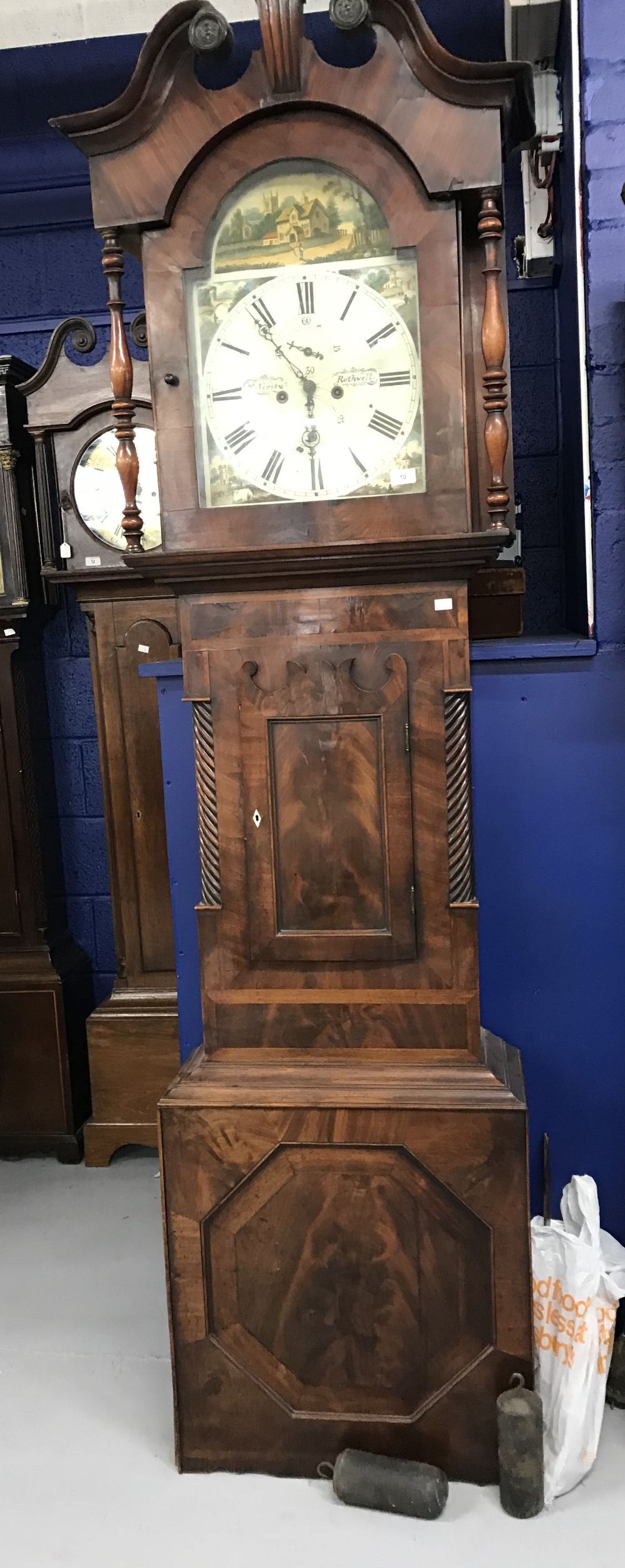 Clocks: 19th cent. Mahogany longcase. Arch dial, painted rural scene, spandrel bell strike second