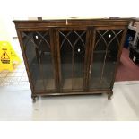 20th cent. Mahogany three door glazed bookcase, Gothic arch mouldings, on cabriole supports. 46½ins.