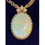 Hallmarked Gold: 18ct. Fine opal oval pendant set with three diamonds and double suspension loops.