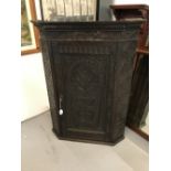 18th cent. Oak corner cupboard, ornately carved, with locking door, two serpentine shelves to the