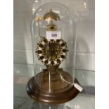 Clock: 20th cent. Brass skeleton clock chiming on the hour, treen base and circular glass dome.