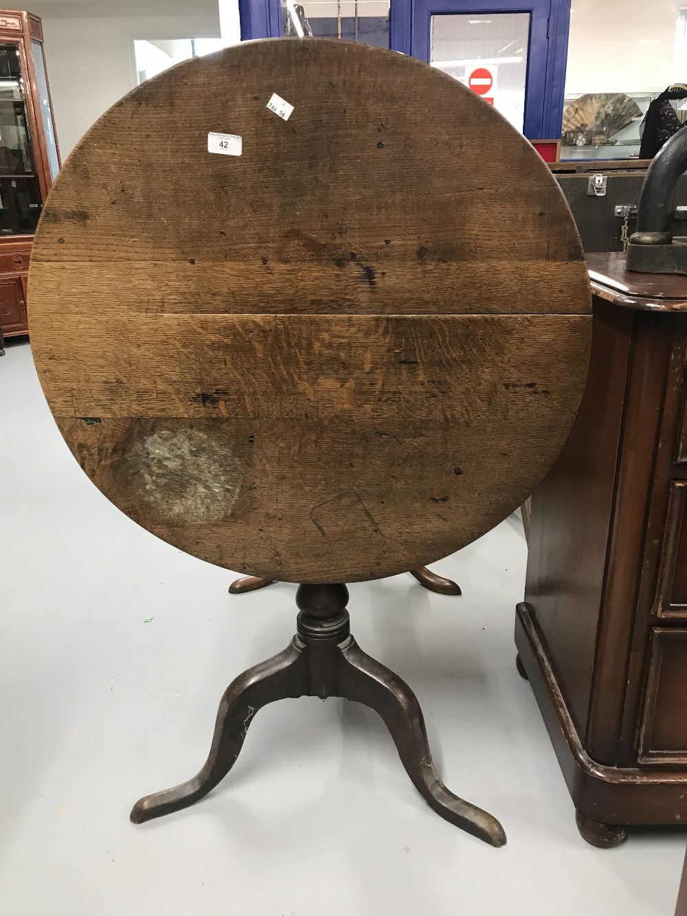 19th cent. Oak tilt top table on single turned support with tripod feet. Diameter 28ins.