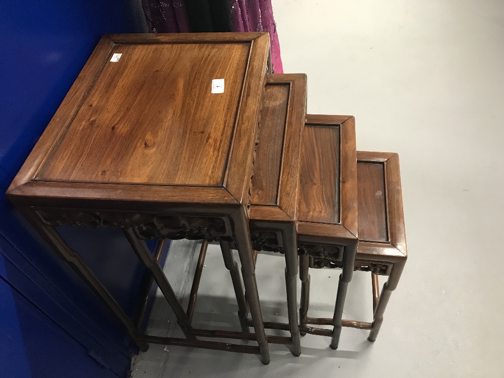 20th cent. Chinese hardwood furniture. Nest of four tables with heavily carved decoration made by C. - Image 2 of 3