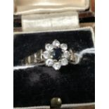 Hallmarked Gold: 9ct. Ring, floral cluster set with one blue C.Z. surrounded by eight CZ. Hallmarked