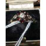 Hallmarked Gold: 9ct. Seven stone floral cluster ring, centre white stone surrounded by six garnets,
