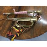 Musical Instruments: Two brass bugles with braided decoration. 21ins. and 11ins. Long.