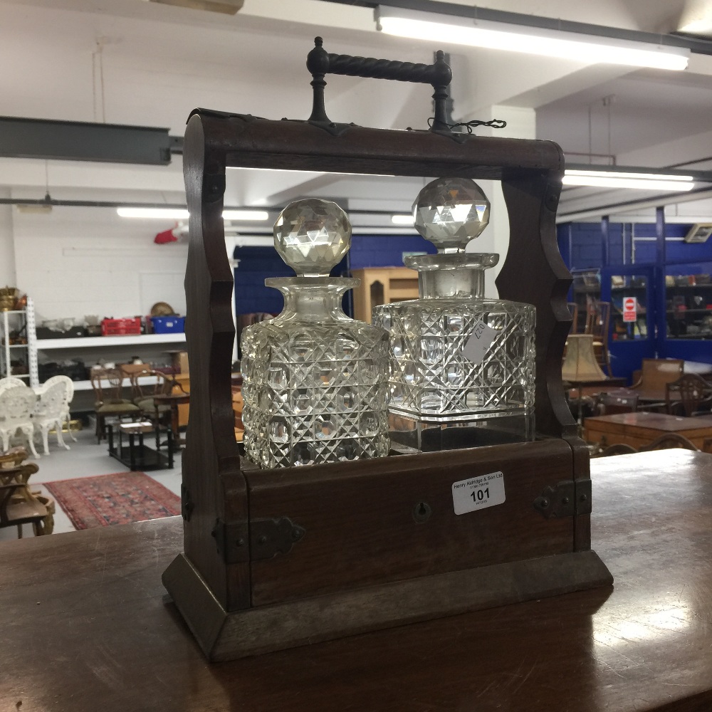 20th cent. Oak tantalus with two decanters.