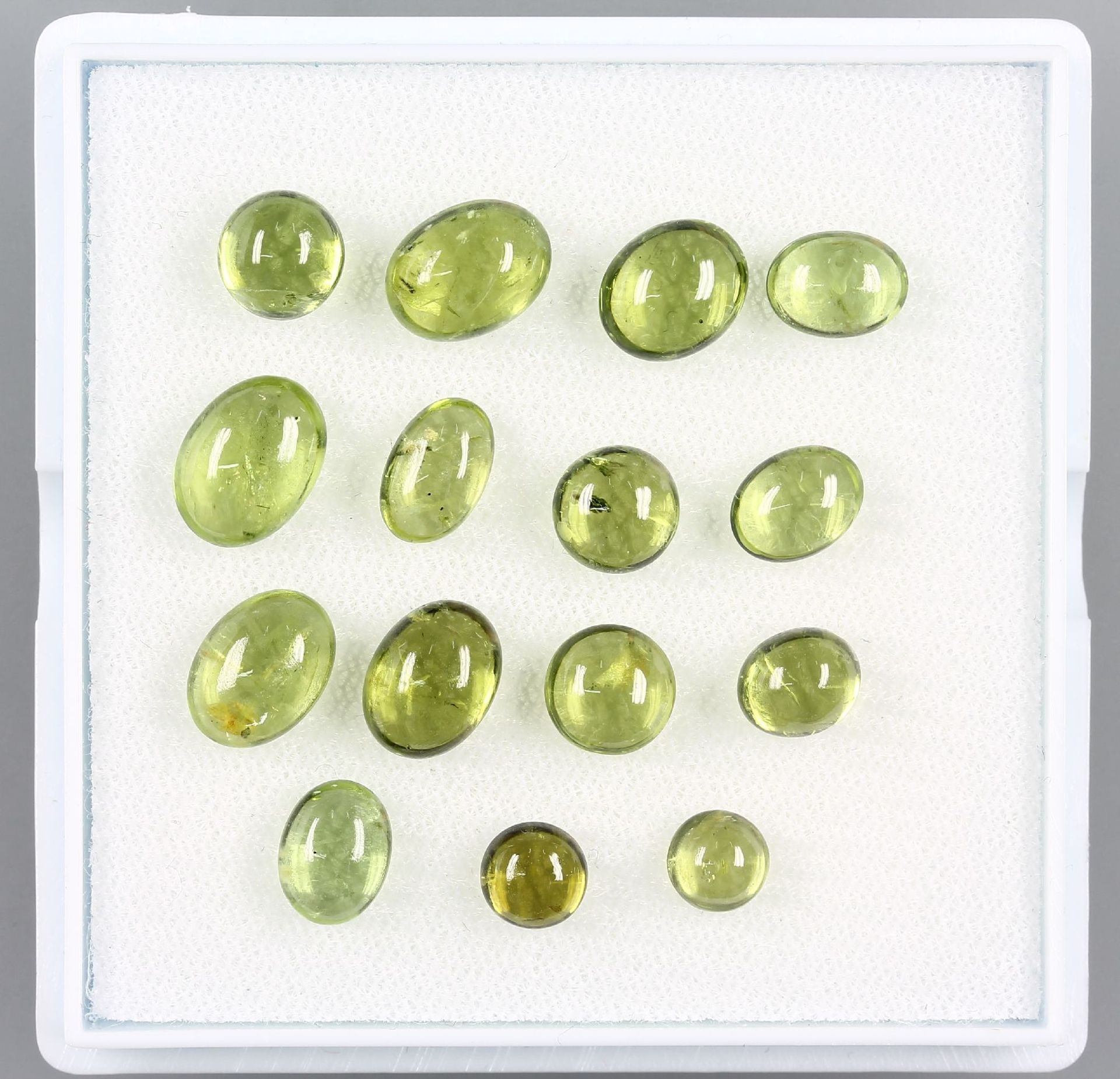 Lot 15 lose Peridotcabochons zus. ca. 30.49 ct, in versch. Größen, überwiegend oval Schätzpreis: