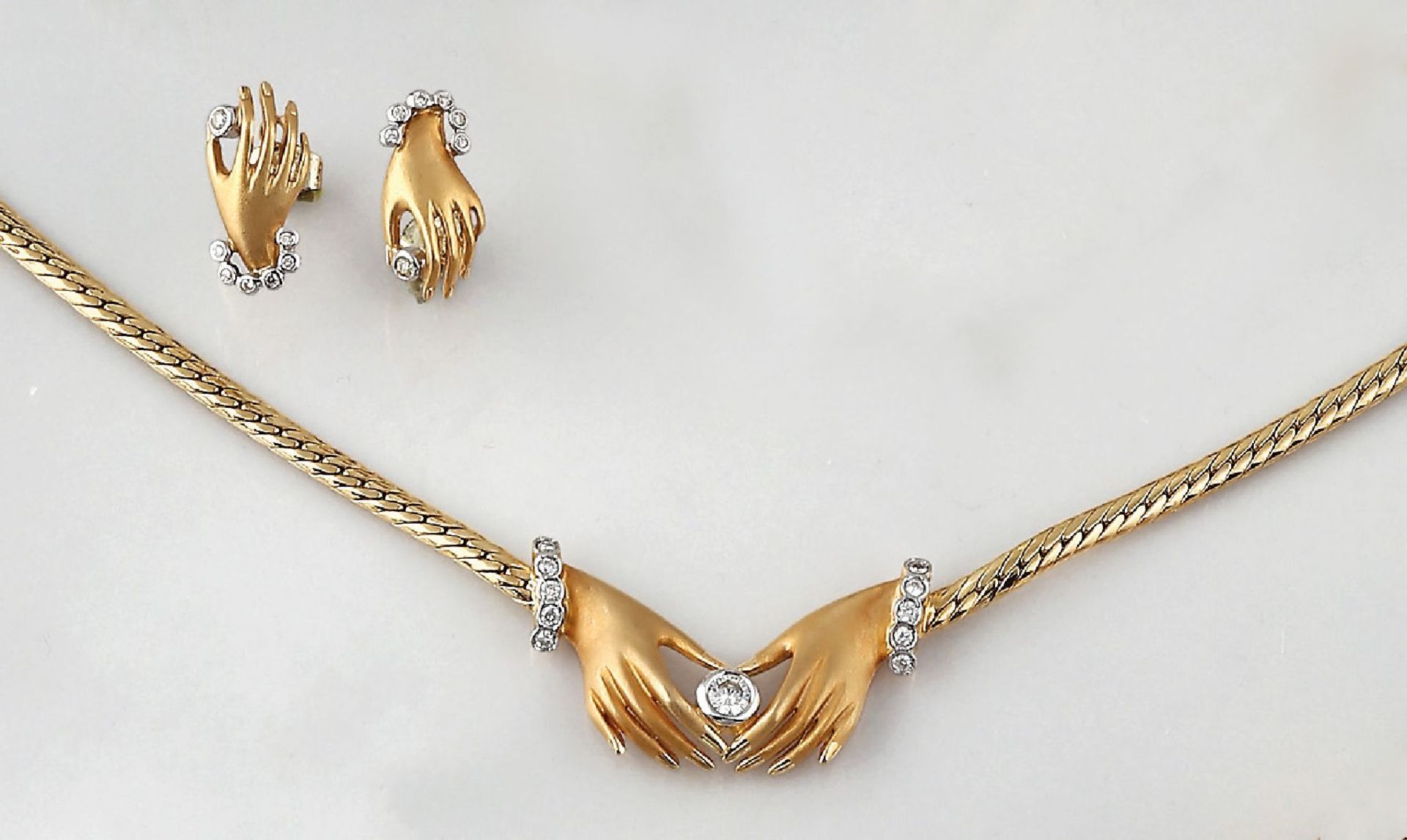 18 kt Gold Schmuckset "Hände" mit Brillanten, best. aus: Collier und Paar Ohrstecker, GG 750/000,