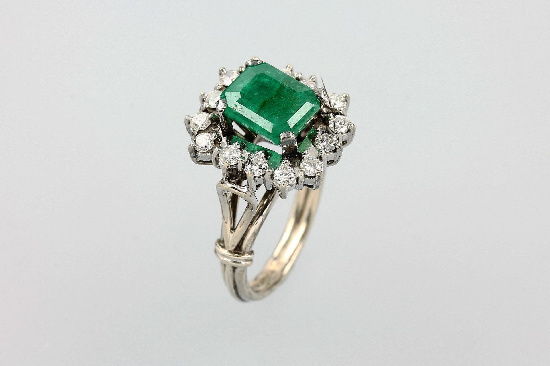 Ring mit Smaragd und Brillanten, WG 585/000, mittig rechteckig facett. Smaragd ca. 1.20 ct, Kerben/