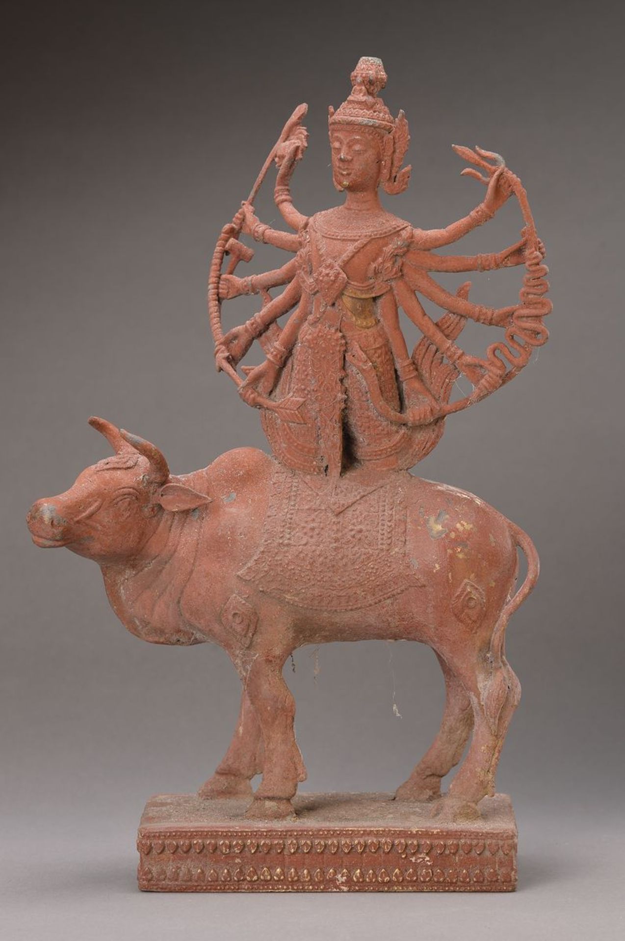 Bronzeskulptur, Siam um 1900, acht-armige Gottheit auf einem Rind kniend, Bronze, rot gefaßt, ca. 39