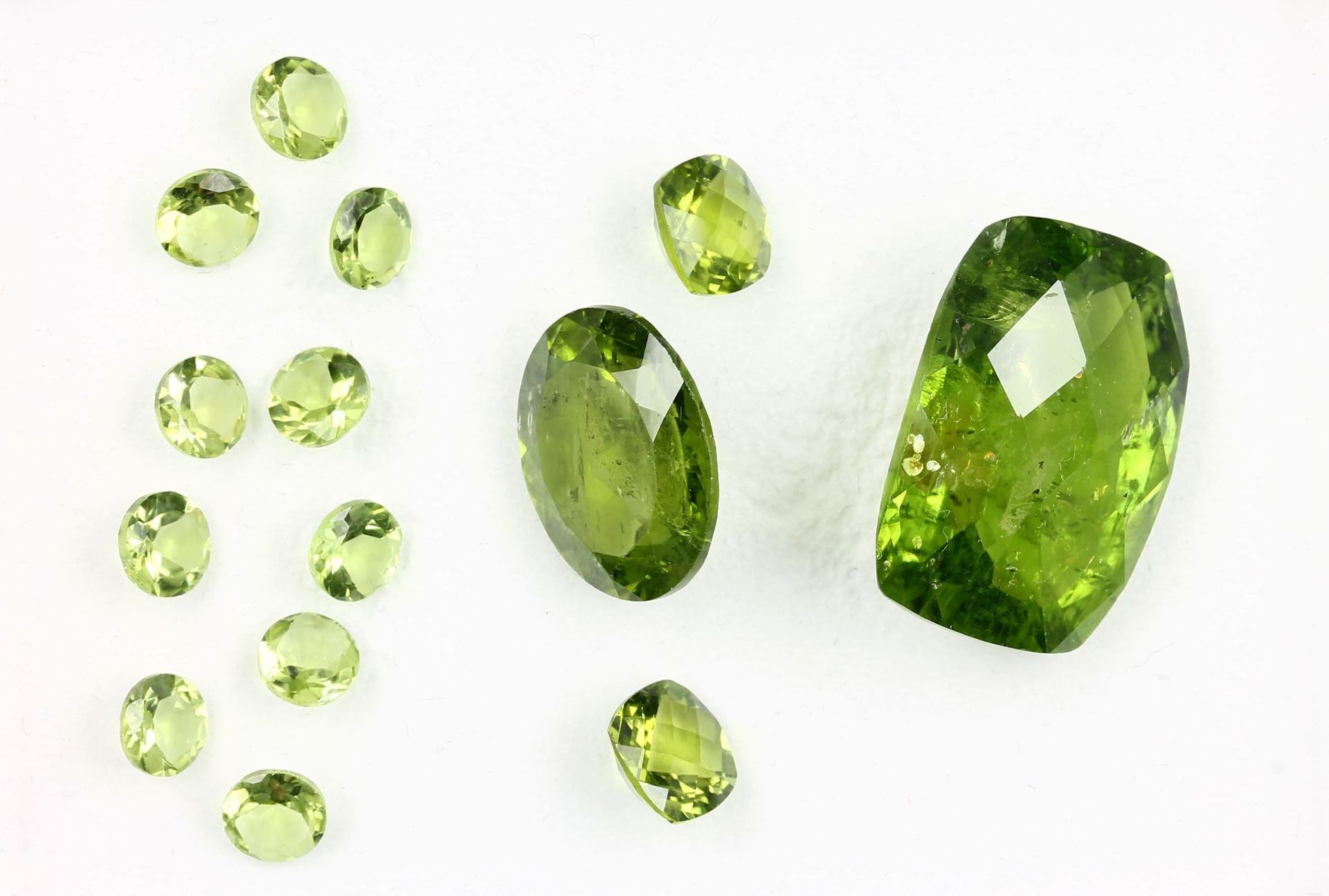 Lot lose Peridots, best. aus: 10 x rund facett. zus. ca. 8 ct, 1 x Kissenschliff ca. 33.5 ct, 1 x