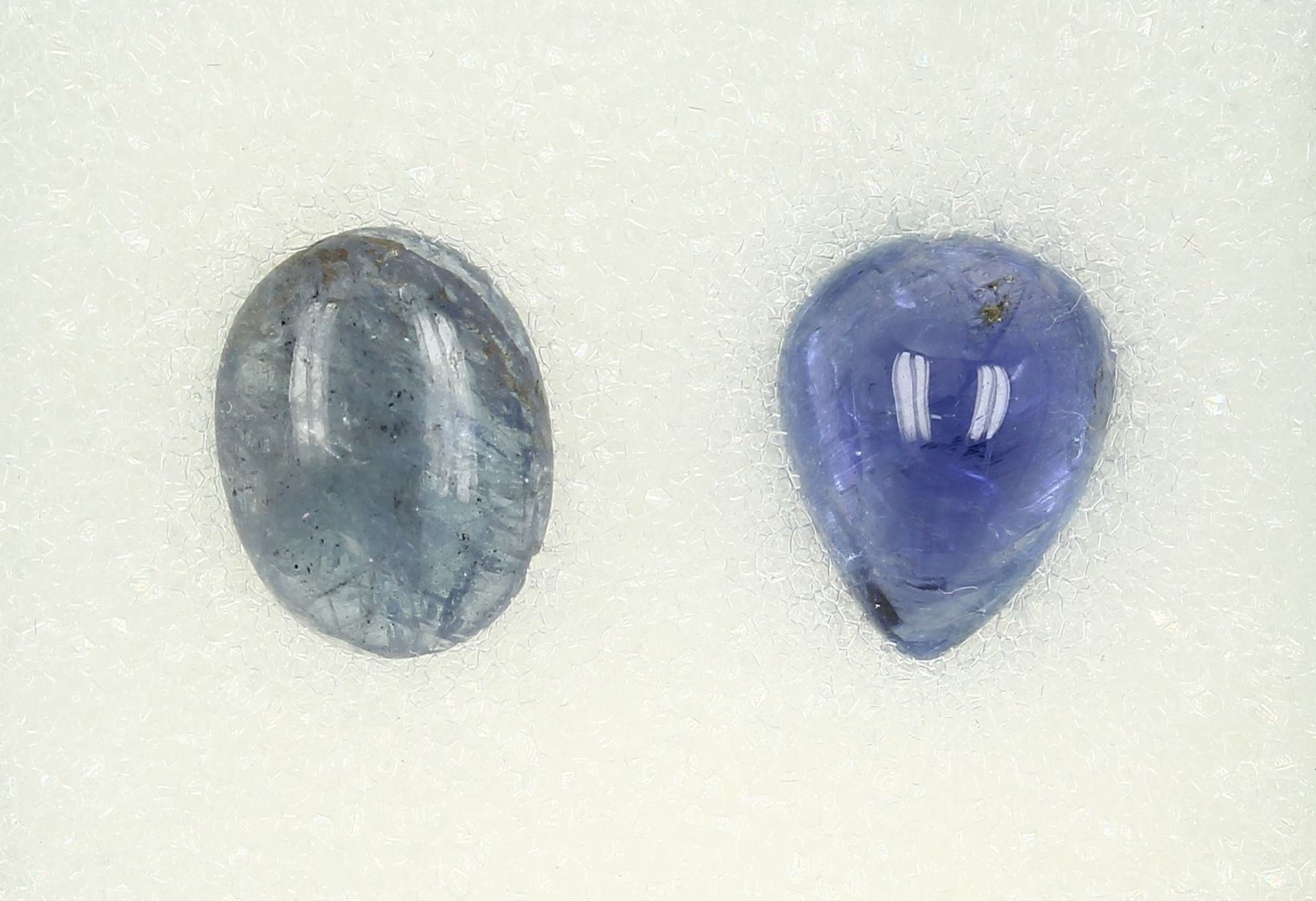 Konvolut 2 Tansanit-Cabochons: 1 x Tropfenform ca. 6.7 ct; 1 x oval ca. 5.19 ct Schätzpreis: