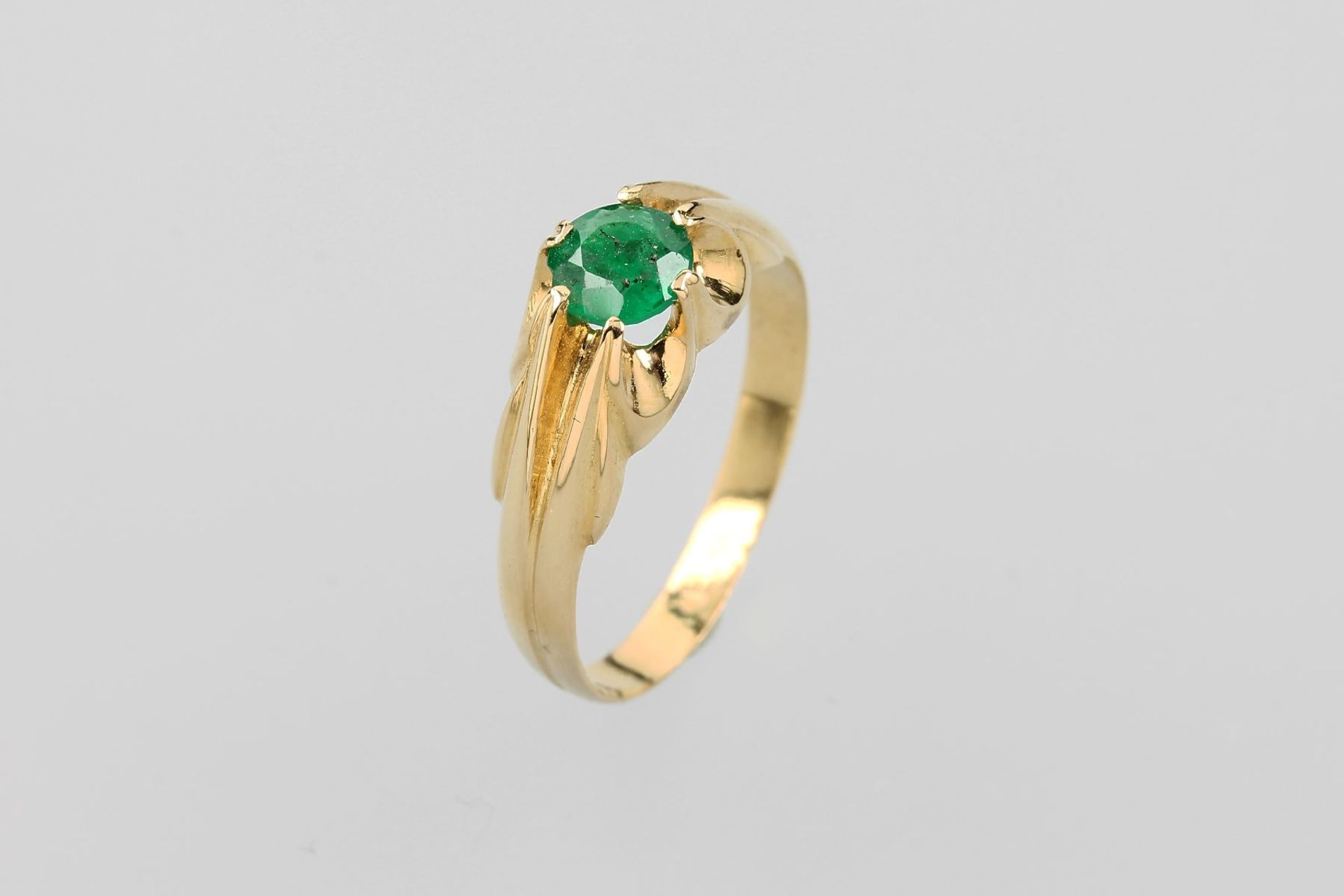 18 kt Gold Ring mit Smaragd, GG 750/000, mittig rund facett. Smaragd ca. 0.70 ct, Ringschultern