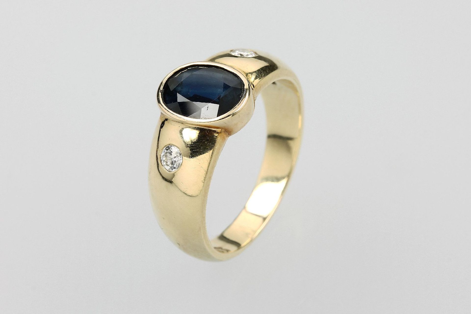 14 kt Gold Ring mit Saphir und Brillanten, GG 585/000, mittig ovalfacett. Saphir, seitl. 2