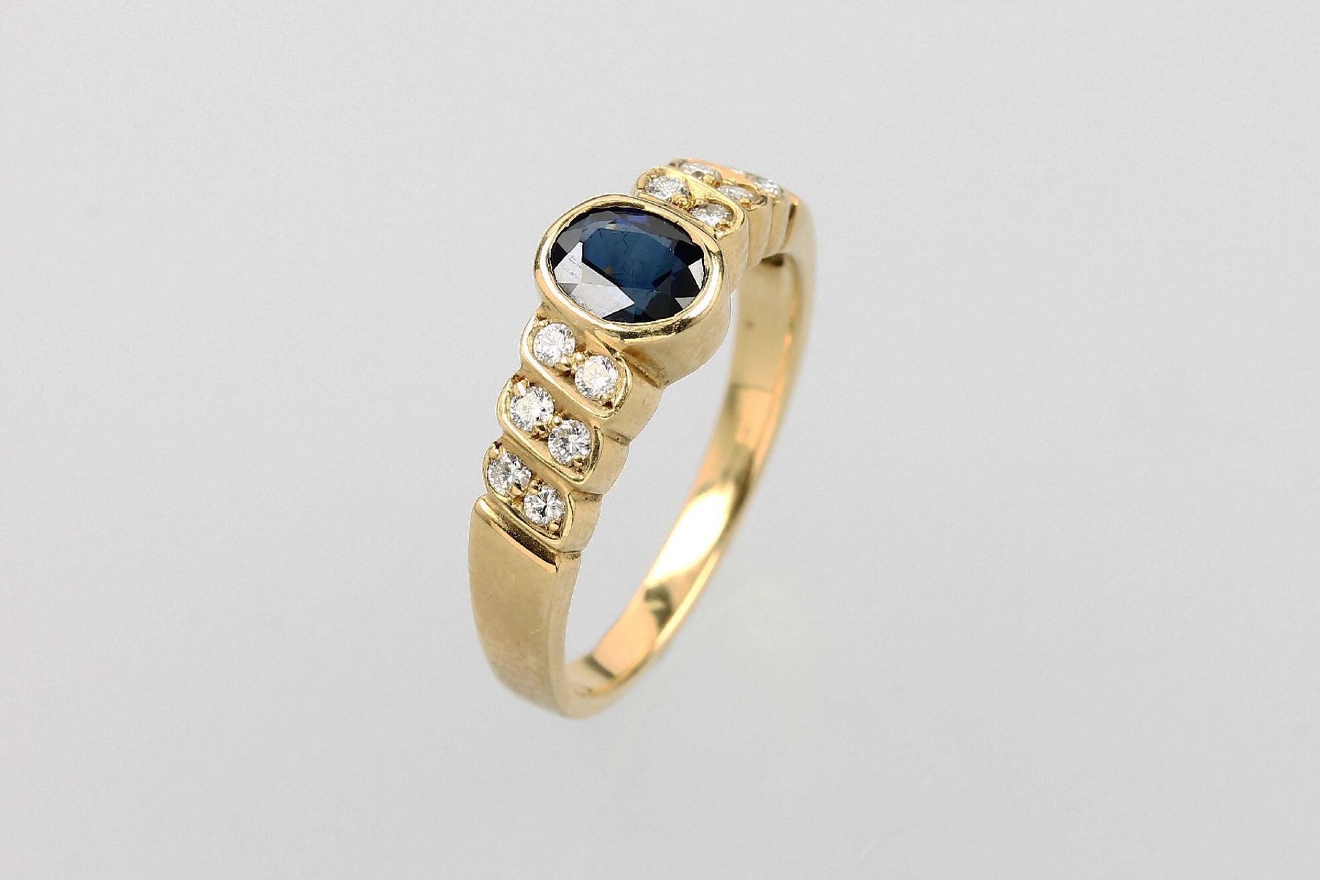 18 kt Gold Ring mit Saphir und Brillanten, GG 750/000, ovalfacett. Saphir ca. 0.40 ct, seitl.