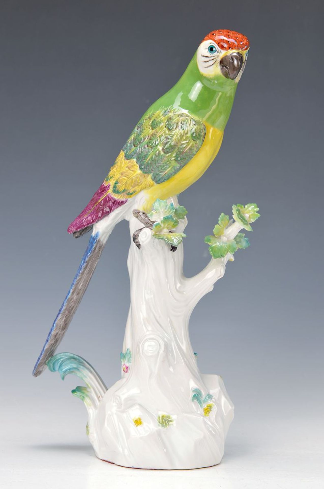 Porzellanfigur, Meissen, 20. Jh., Papagei auf Baumstumpf, bunt bemalt, Blattwerk leicht best., H.