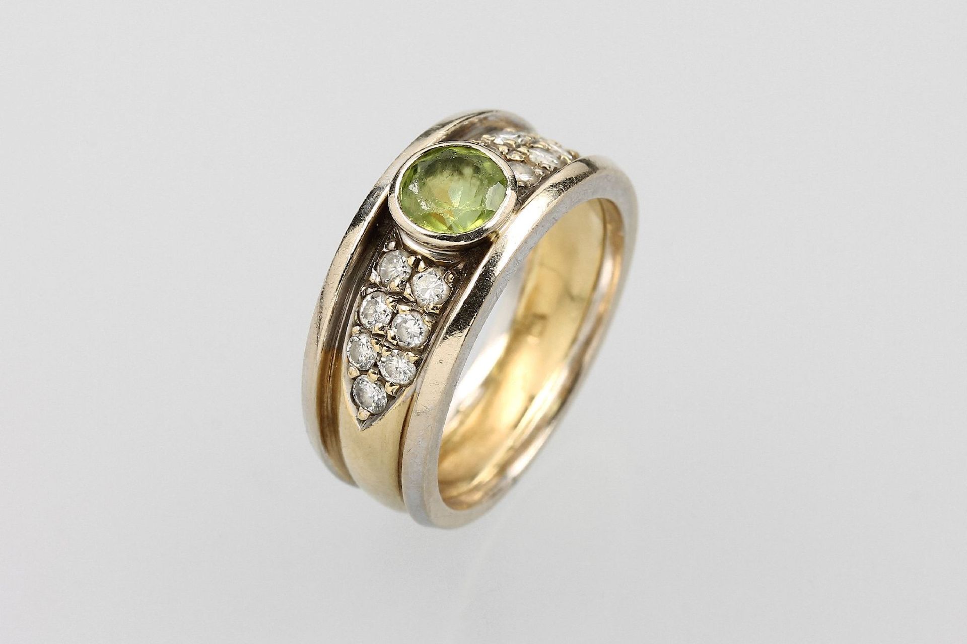 18 kt Gold Ring mit Peridot und Brillanten, GG/WG 750/000, mittig rundfacett. Peridot, seitl. 14