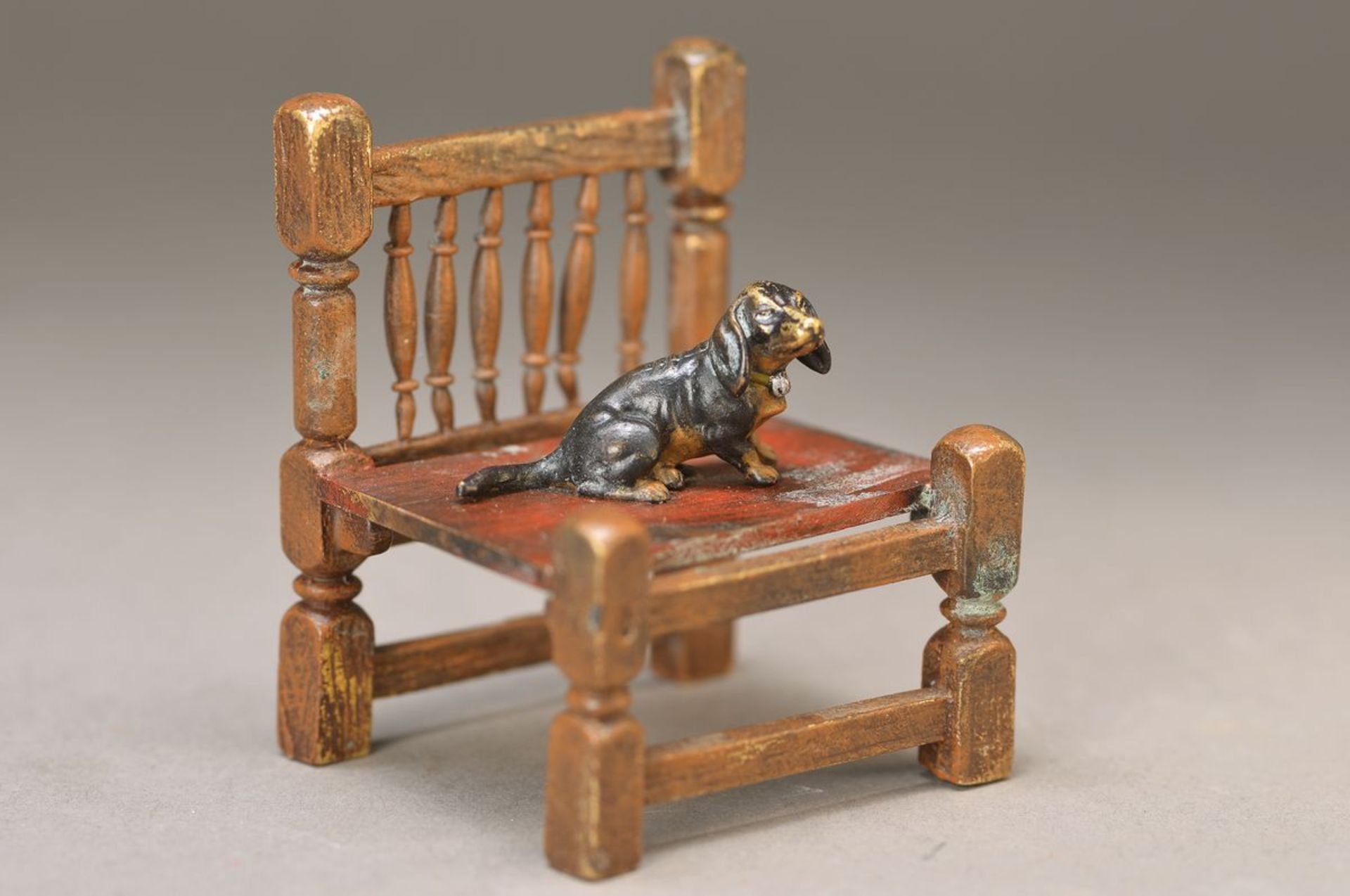Wiener Bronze, 2.H.20.Jh., Bronze, bunt staffiert, Dackel auf einem Stuhl sitzend, sign. Bergmann,
