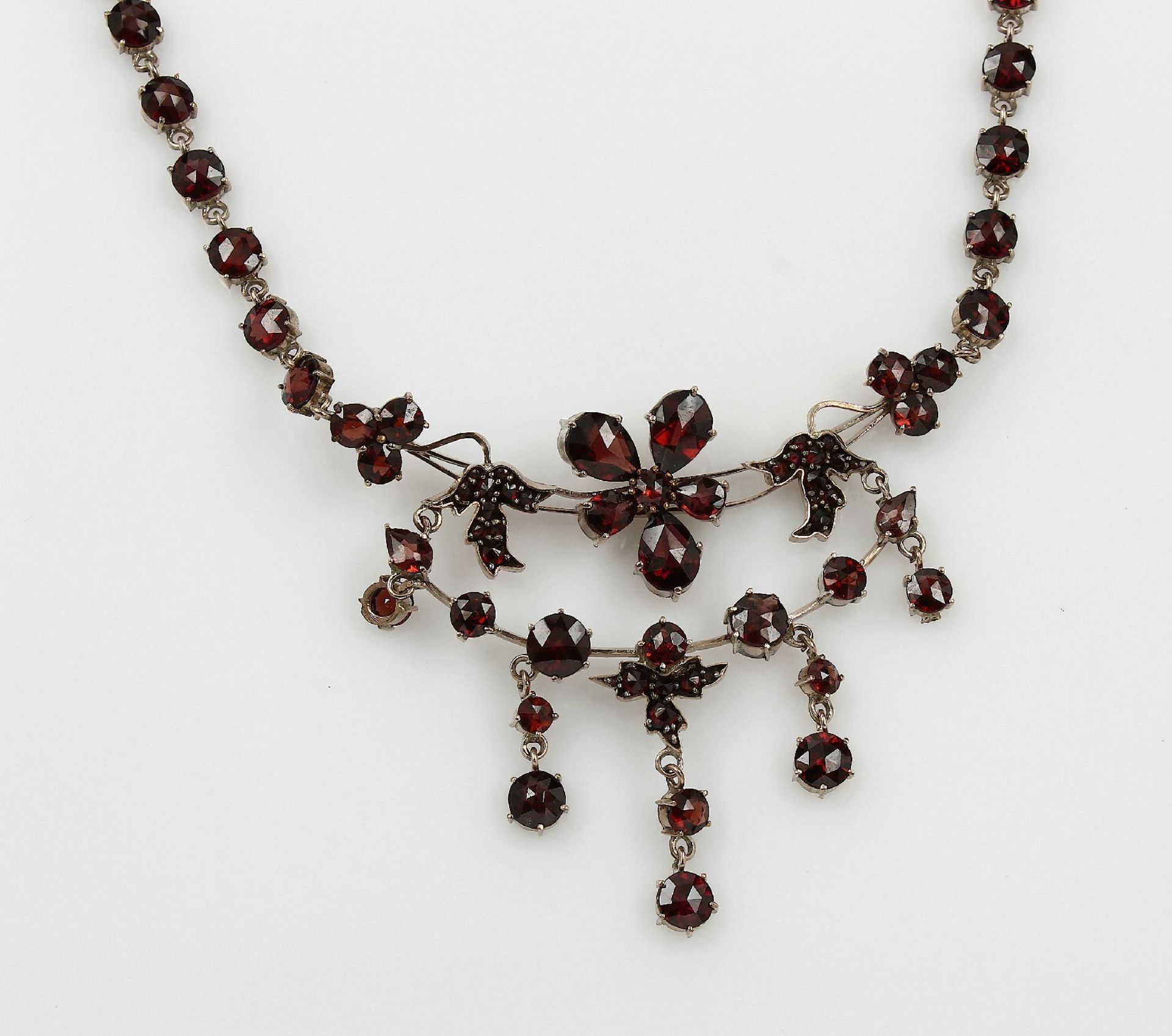 Collier mit Granaten, Berlin um 1930, Tombak, florales Mittelteil, bes. mit facett. Granaten, von