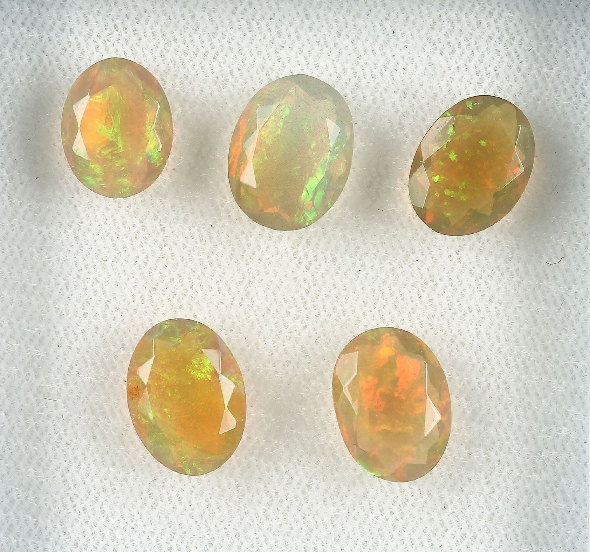 Lot lose Opale, zus. ca. 8.9 ct, oval facett., Farbspiel in Grün, Gelb und Rot, versch. Größen