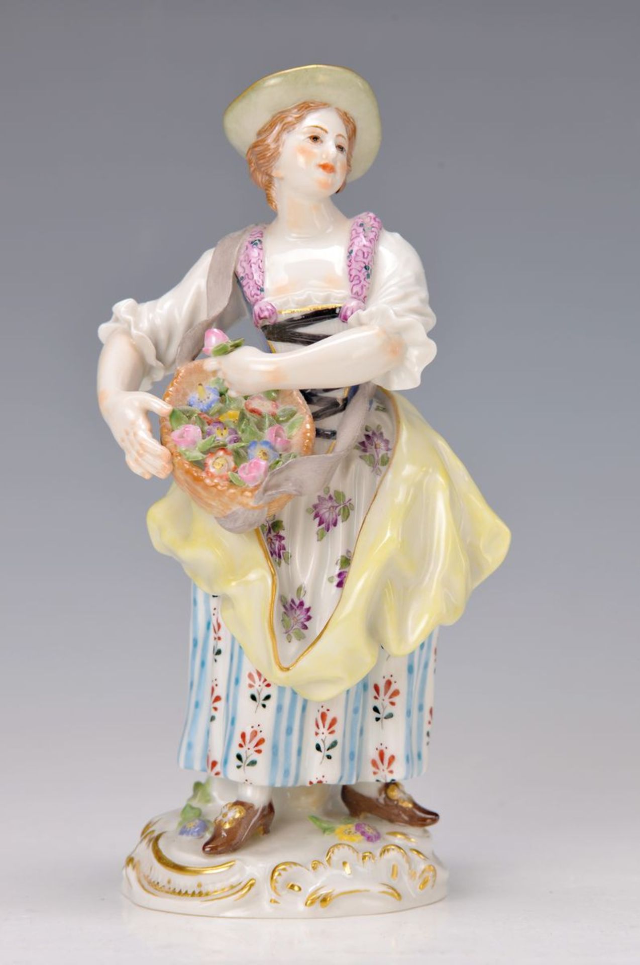 Porzellanfigur, Meissen, 20. Jh., Gärtnerin, bunt bemalt, Korb mit vollplastischen Blüten,