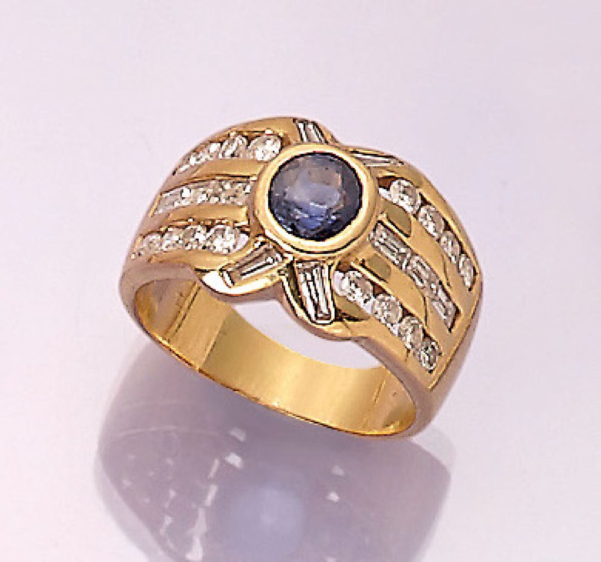 18 kt gold ring with sapphire and diamonds ,YG 750/000, centered with round bevelled sapphire