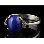 14kt witgouden ring gezet met een cabochon geslepen stersaffier, geflankeerd door 4 achtkant