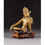 SITZENDE GOTTHEIT Indien/Nepal, wohl 18. Jh. Bronze, part. vergoldet. H. 25,8 cm (Figur). Unterseite