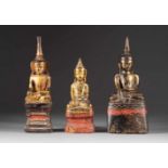 DREI SITZDENDE BUDDHAS Thailand, 19. Jh. Holz, farbig gefasst, Goldstaffage. H. 27 cm-34,5 cm. Part.