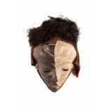 MASKE Afrika, 2. Hälfte 20. Jh. Holz, Pflanzenfaser, Raphia-Bast, weiße Farbpigmente. H: 33 cm.