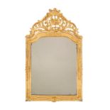 Miroir cintré. XIXe s.. en bois sculpté et doré à décor de coquilles et agrafes. surmonté d'un front