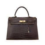 Hermès. sac Kelly 32 en crocodile havane acajou brillant. bandoulière. tirette et clochette 2 clefs.