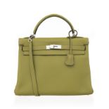 Hermès. sac Kelly 32 en cuir Clémence vert anis. tirette et clochette avec 2 clefs. bandoulière. pro