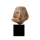 Buste en quartzite sculpté. Egypte. Nouvel Empire. visage d'homme avec coiffure en mèches étagées. h