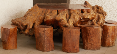 A LARGE ROOT WOOD TABLE WITH EIGHT STOOLS