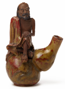 A 'SHIWAN' POTTERY FIGURE OF A MAN SITTING ON A DOUBLE GOURD